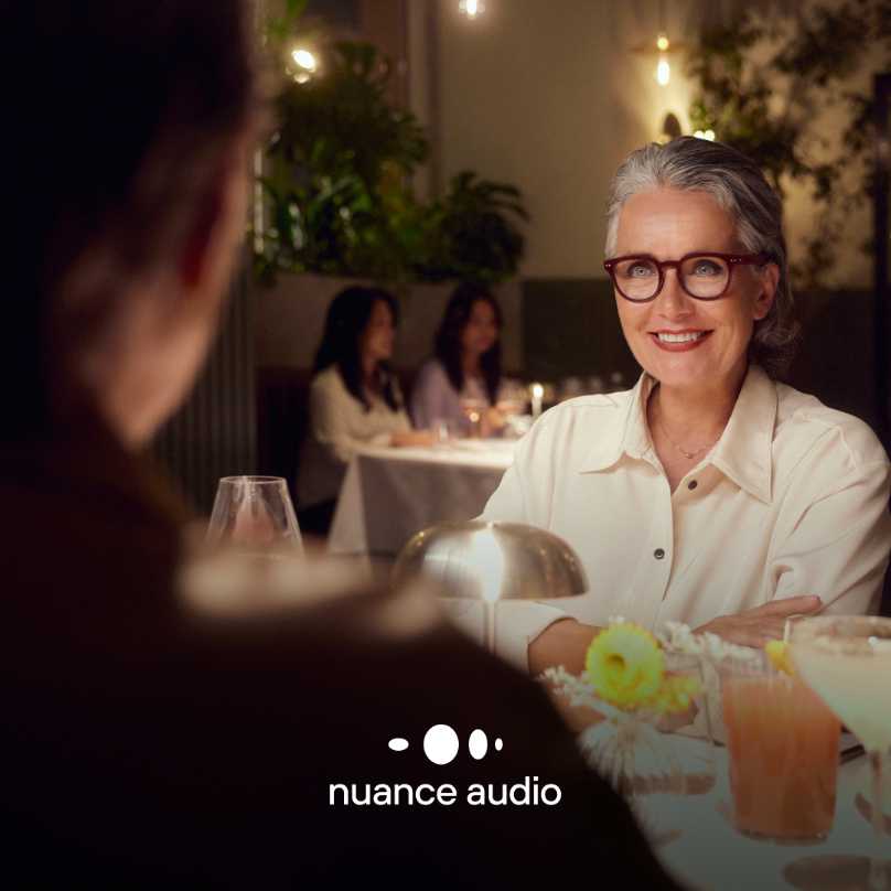 Frau im Restaurant mit Hörbrille